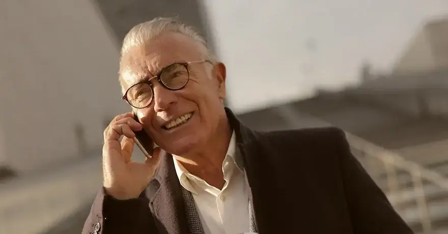 Man med svart kavaj och glasögon går nerför en trappa och talar i en mobiltelefon.